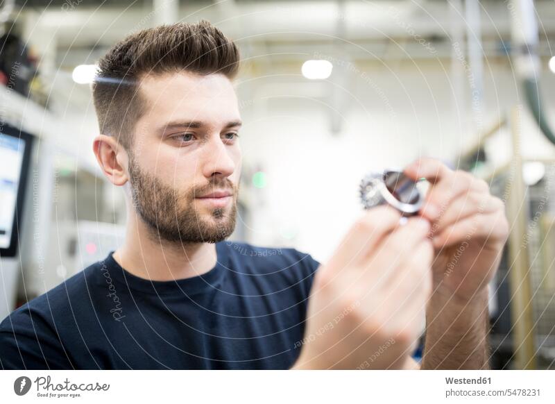 Man examining workpiece in a factory Occupation Work job jobs profession professional occupation blue collar blue collar worker blue-collar worker workers