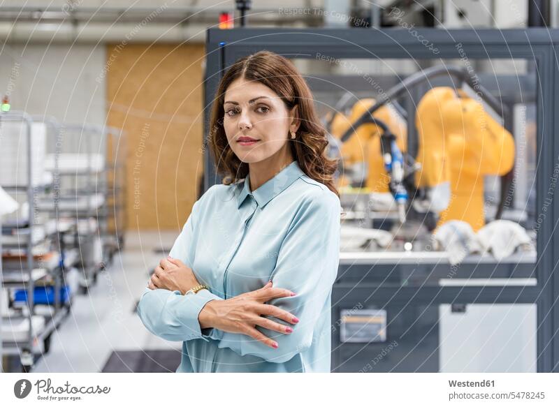 Portrait of a businesswoman, working in a manufacturing company industry industrial firm automaton machine robot robots businesswomen business woman