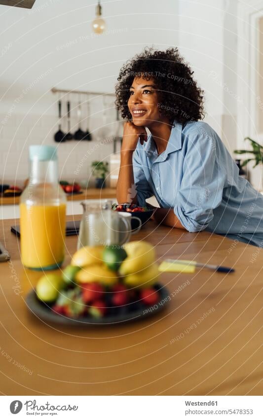 Woman having a healthy breakfast in her kitchen smiling smile domestic kitchen kitchens morning in the morning standing Breakfast Fruit Fruits mid adult women
