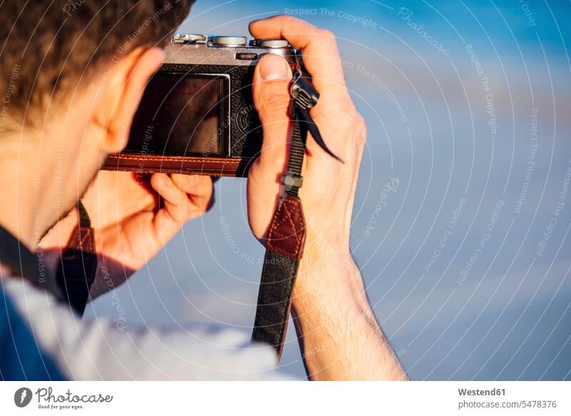 Close-up of young man taking picture with old-fashioned camera men males photographing cameras Adults grown-ups grownups adult people persons human being humans