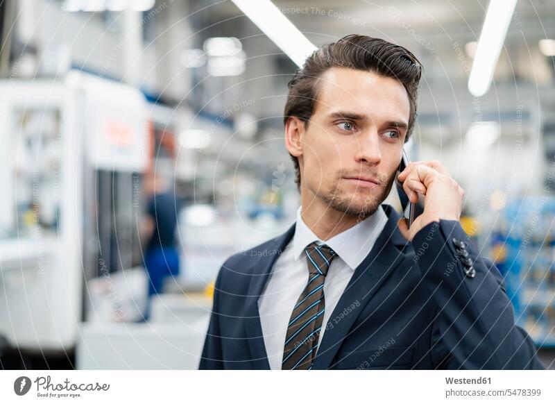 Portrait of businessman on cell phone in a factory Businessman Business man Businessmen Business men on the phone call telephoning On The Telephone calling