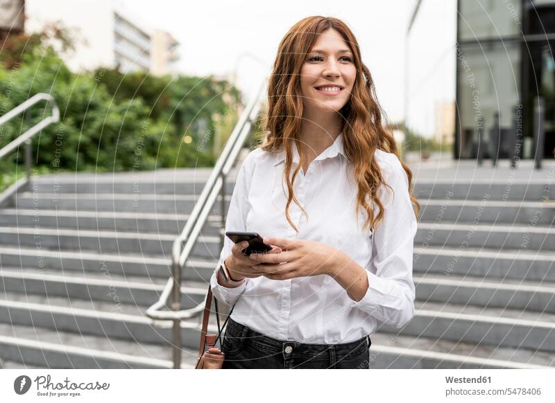 Young businesswoman walking down stairs, using smartphone use stairway on the move on the way on the go on the road urban urbanity Smartphone iPhone Smartphones