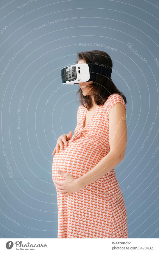 Woman pretending to be pregnant, using VR glasses touching Virtual Reality Glasses Virtual-Reality Glasses virtual reality headset vr headset vr goggles