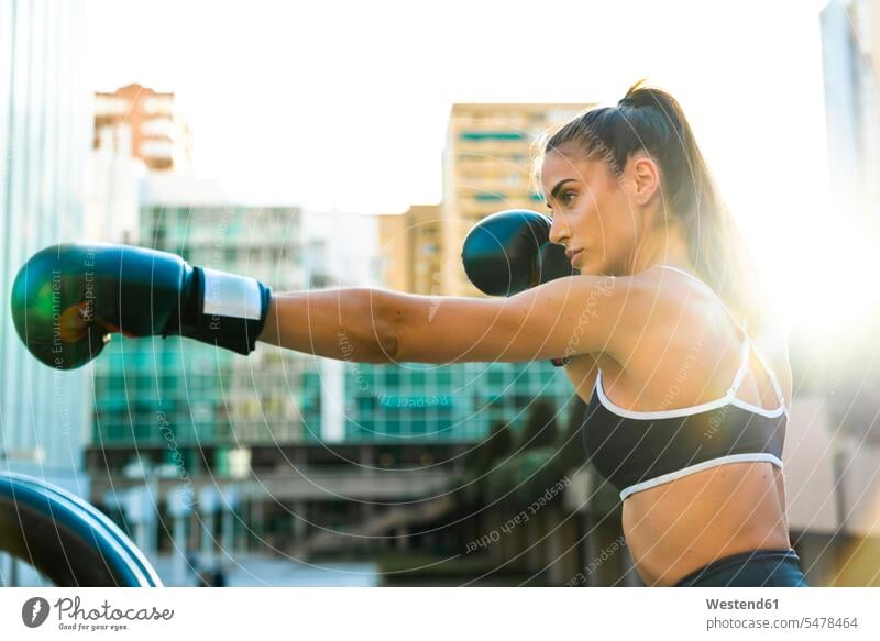 Sportive young woman boxing in the city town cities towns females women sportive sporting sporty athletic outdoors outdoor shots location shot location shots