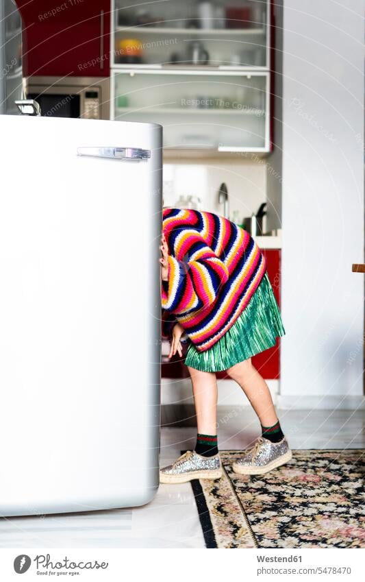 Girl in striped pullover in kitchen at home looking in fridge sweater jumper Sweaters stripes girl females girls view seeing viewing Fridge Ice box Icebox