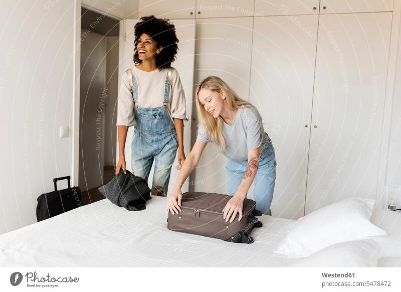 Two smiling women with baggage arriving in accomodation girlfriend Girlfriends girl friend girl friends luggage arrival smile woman females accommodation