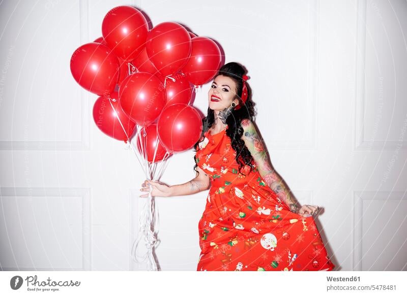 Portrait of tattooed woman with bunch of red balloons females women portrait portraits decoration decorating decorations Adults grown-ups grownups adult people