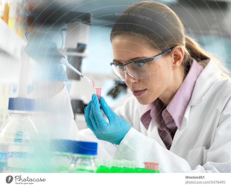 Scientist pipetting sample into a vial ready for automated analysis in the laboratory laboratory technician pipette test testing Lab Tech science sciences