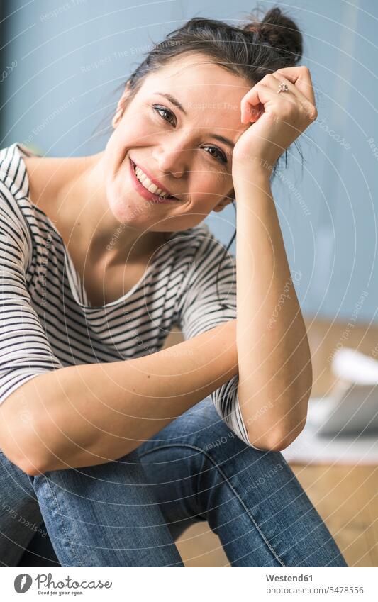 Portrait of happy woman sitting on the floor at home floors portrait portraits Seated females women happiness Adults grown-ups grownups adult people persons