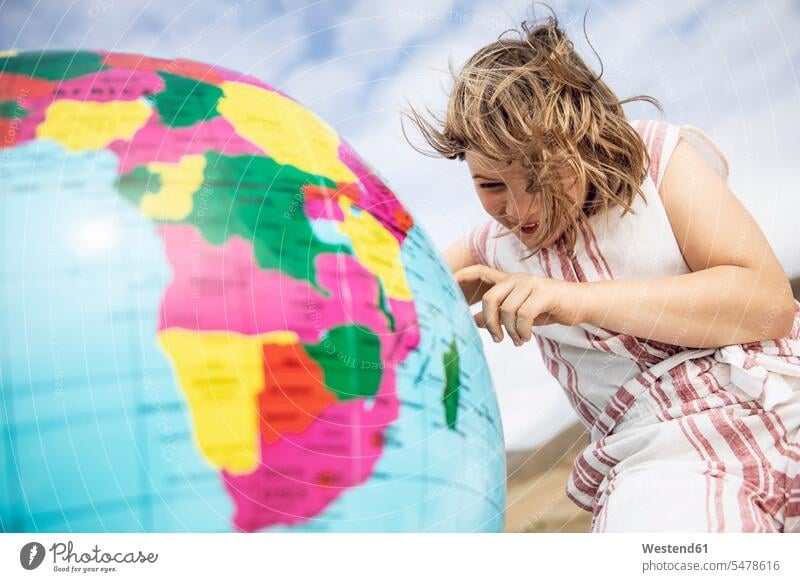 Little girl pointing on inflatable globe globes discover discovering learn smile delight enjoyment Pleasant pleasure happy content Contented Emotion pleased