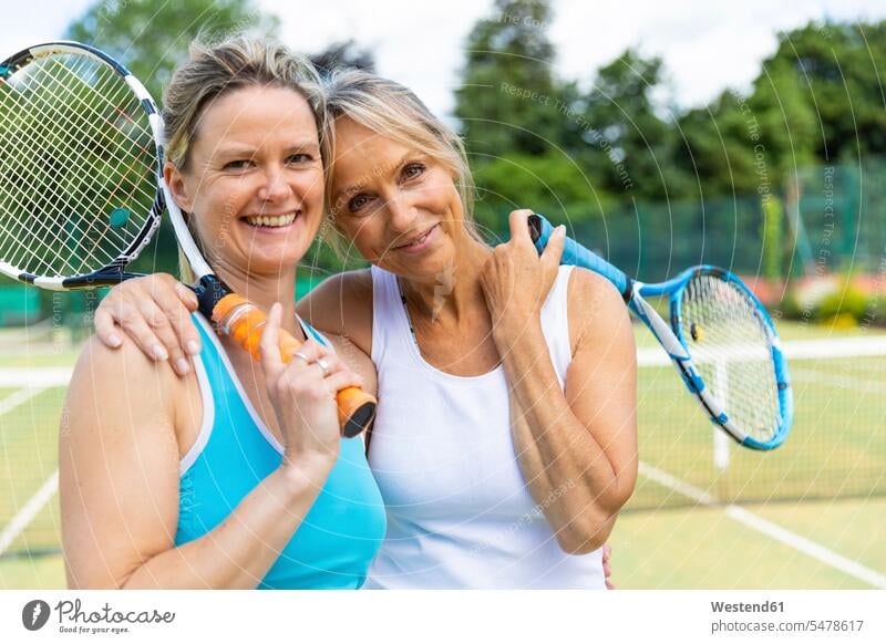 Portrait of two happy mature women on grass court at tennis club human human being human beings humans person persons caucasian appearance caucasian ethnicity