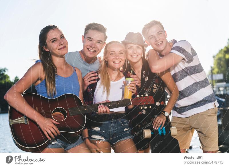 Portrait of group of happy friends with guitar at the riverside riverbank group of people Group groups of people mate River Rivers happiness portrait portraits