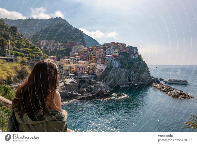 Italy, Liguria, La Spezia, Cinque Terre National Park, young woman looking to Manarola Traveller Travellers Travelers observation point viewpoint lookout point