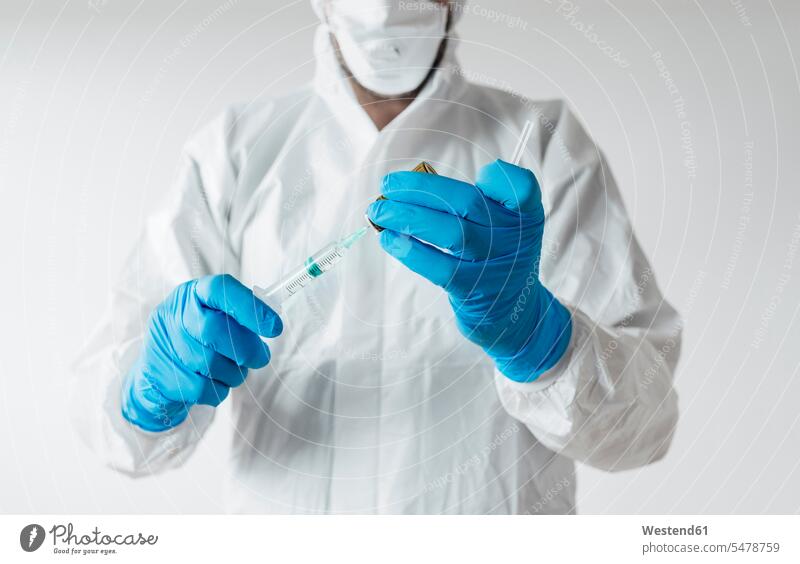 Laboratory technician wearing protective wear, holding vaccine (value=0) Occupation Work job jobs profession professional occupation gloves At Work White Colors