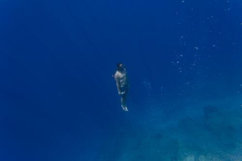 Indonesia, Bali, Young man snorkeling diving dive snorkeler snorkeller snorkelers snorkellers holding breath people persons human being humans human beings