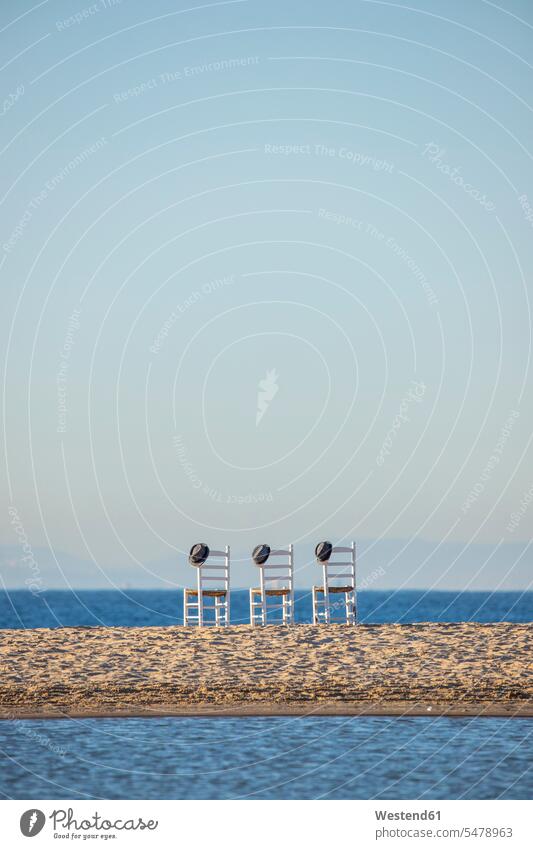Three empty chairs with hats side by side in front of the sea Memory memories Wanderlust Itchy Feet Nostalgia nostalgic Repetition repeating community