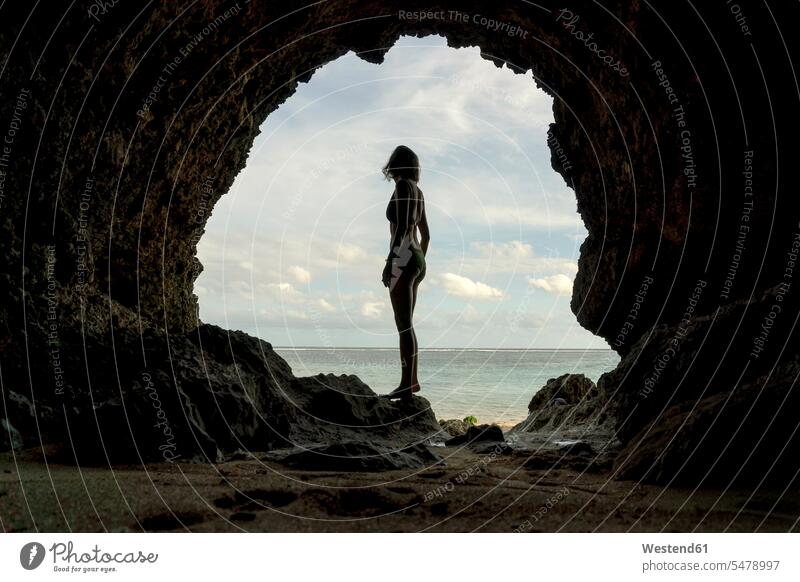 Young woman in cave females women beach beaches standing cavern caves caverns Adults grown-ups grownups adult people persons human being humans human beings