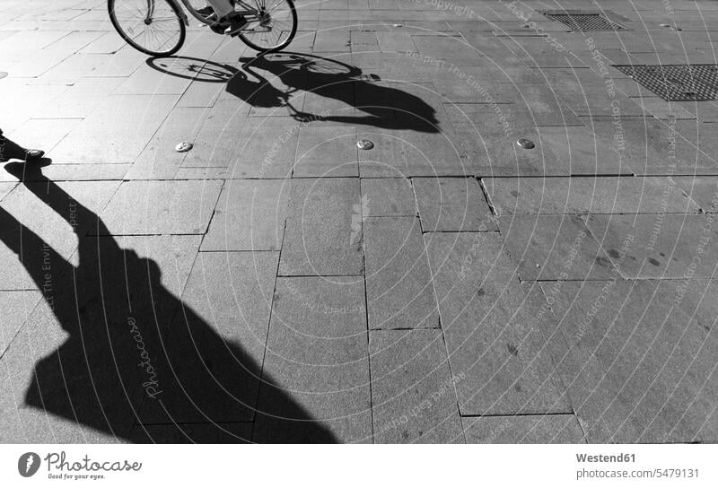 Shadows on a pavement, Seville, Spain silhouettes contrasting Contrasts opposite opposites human human being human beings humans person persons bicyclist
