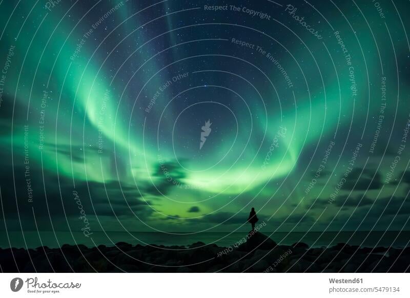 Norway, Lofoten Islands, Eggum, man standing on rock and watching northern lights alone solitary solo men males Wanderlust Itchy Feet Adventure adventurous