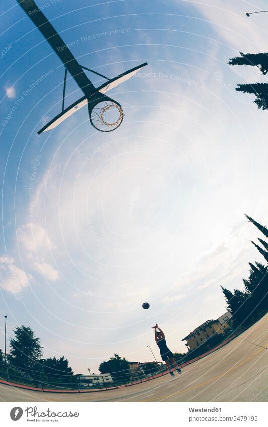 Fish-eye view of teenage girl playing basketball against sky color image colour image outdoors location shots outdoor shot outdoor shots day daylight shot
