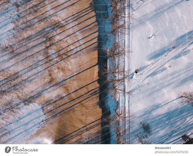 Russia, Leningrad Oblast, Tikhvin, Aerial view of snow-covered road stretching along frozen pond outdoors location shots outdoor shot outdoor shots day