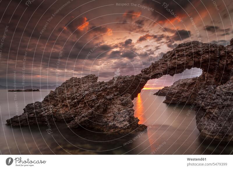 Spain, Girona, Escola, Clouds over natural arch in Costa Brava at dawn outdoors location shots outdoor shot outdoor shots morning twilight in the morning
