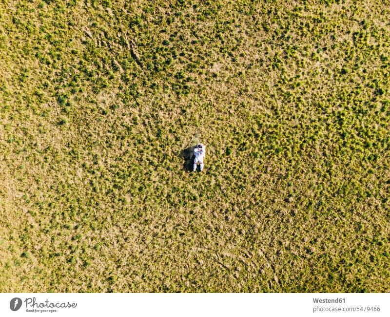 Astronaut lying on land during sunny day color image colour image outdoors location shots outdoor shot outdoor shots daylight shot daylight shots day shots
