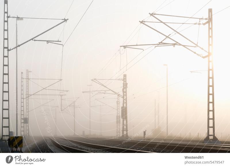 Germany, Hamburg, railway track in early morning fog early-morning haze economy economics morning mist power line current line power supply line outdoors