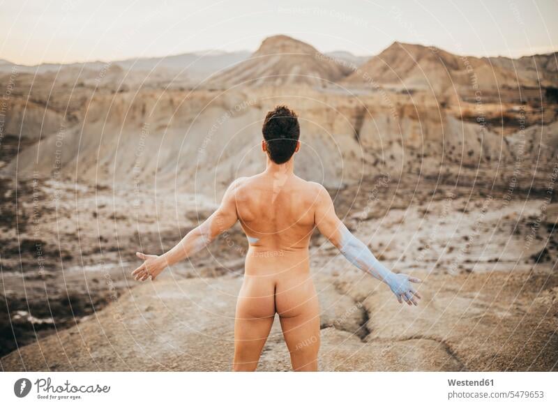 Naked man standing on mountain at desert during sunset color image colour image Spain leisure activity leisure activities free time leisure time outdoors