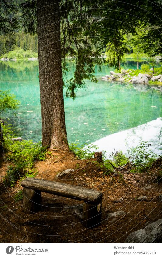 Italy, Province of Udine, Tarvisio, Simple wooden bench on shore of Fusine Lake outdoors location shots outdoor shot outdoor shots day daylight shot