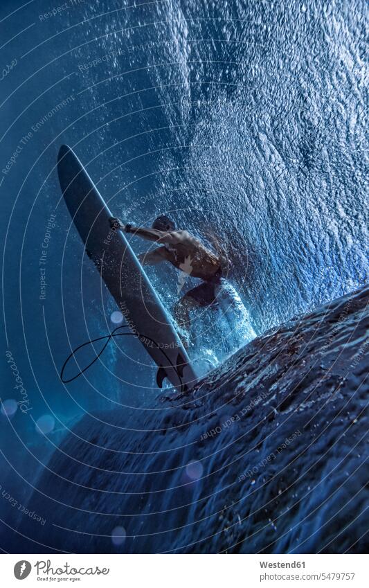 Male surfer surfing on surfboard undersea at Maldives Adventure Adventures adventurous aquatic sport color image colour image day daylight shot daylight shots