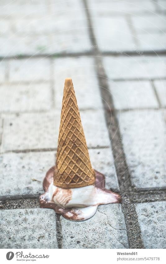 Ice cream cone with melting scoop upside down on the ground copy space focus on foreground Focus In The Foreground focus on the foreground lost pavement paving