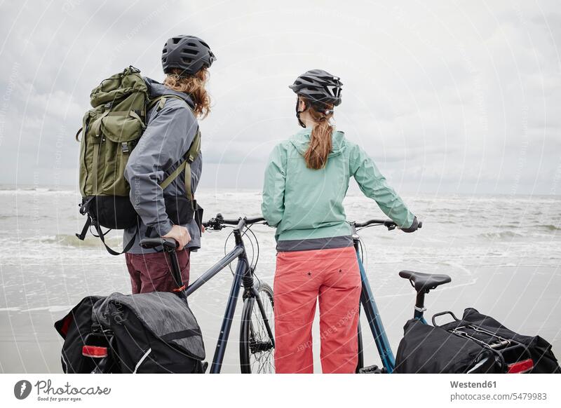 Germany, Schleswig-Holstein, St Peter-Ording, couple with bicycles on the beach bikes beaches twosomes partnership couples transportation people persons