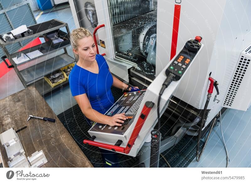 Woman operating control panel in industrial factory factories woman females women working At Work machine Adults grown-ups grownups adult people persons