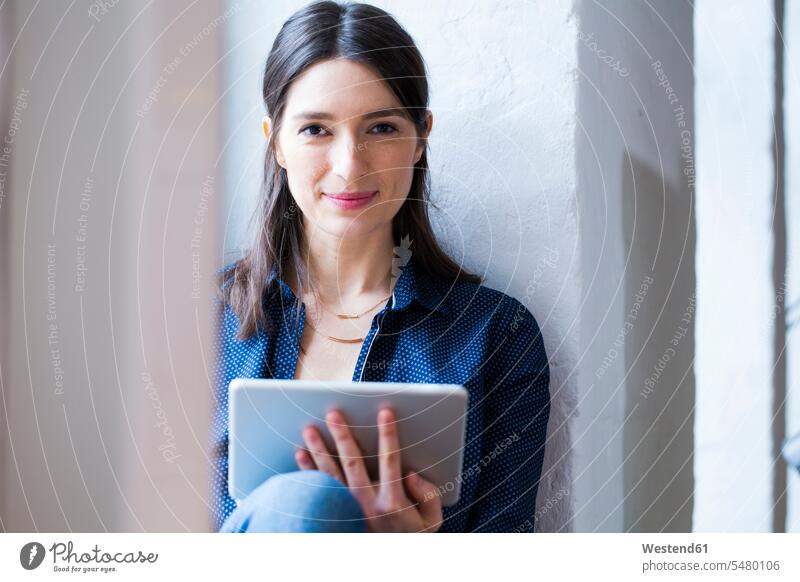 Portrait of confident woman with tablet at the window office offices office room office rooms workplace work place place of work working At Work portrait