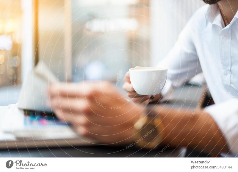 https://www.photocase.com/photos/5480144-close-up-of-businessman-with-cup-of-coffee-reading-newspaper-in-a-cafe-photocase-stock-photo-large.jpeg