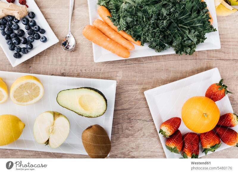 Fresh fruits and vegetables on plates food and drink Nutrition Alimentation Food and Drinks half halves halved wooden Glass Drinking Glasses ginger Kiwi