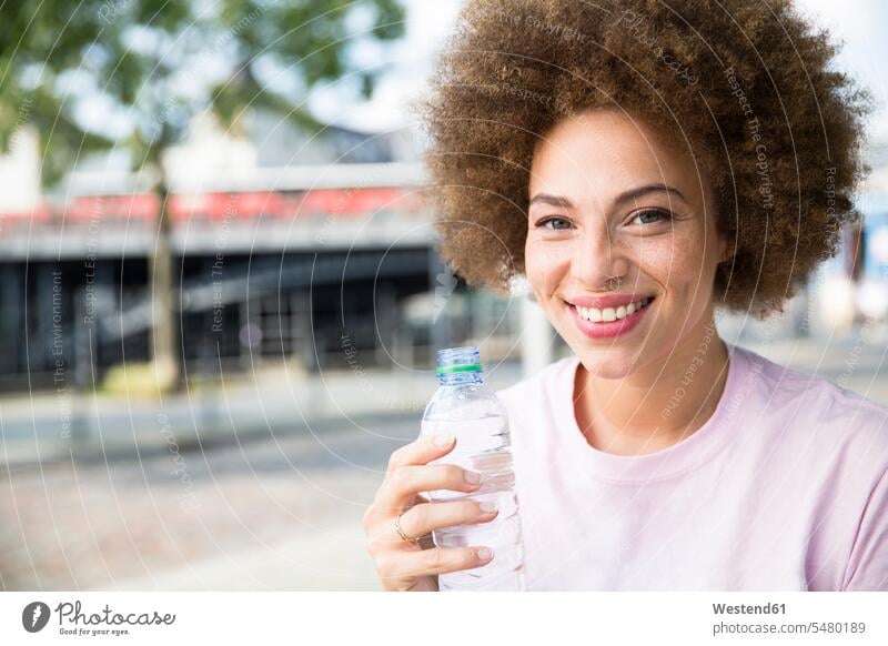 Young woman drinking water females women Water smiling smile Adults grown-ups grownups adult people persons human being humans human beings Drink beverages