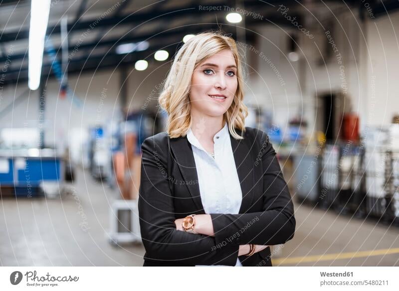 Blonde businesswoman standing on shop floor with arms crossed, portrait portraits manager female managers Arms Folded Folded Arms Crossed Arms Crossing Arms