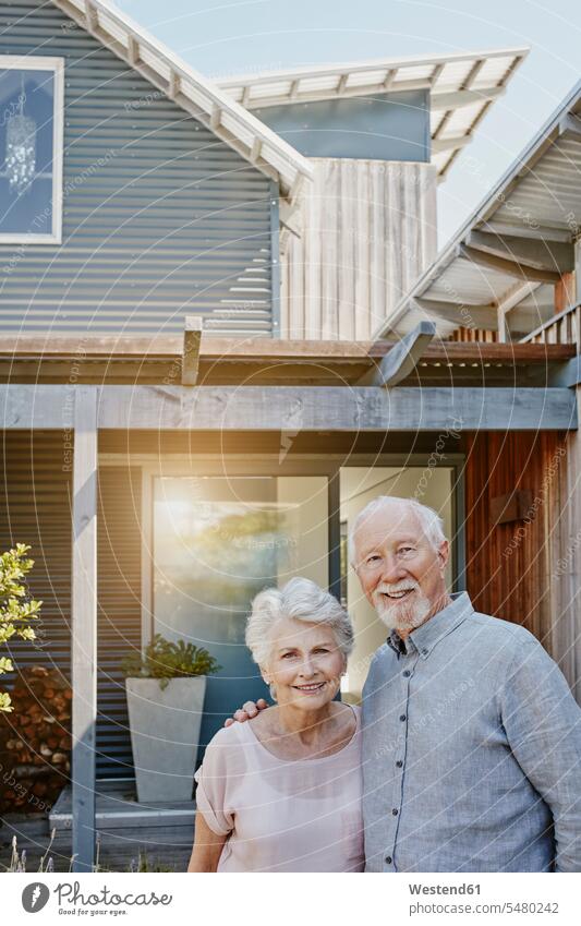 Senior couple standing in front of their house, looking confident happiness happy senior adults seniors old entrance entry Entryway entrances terrace terraces