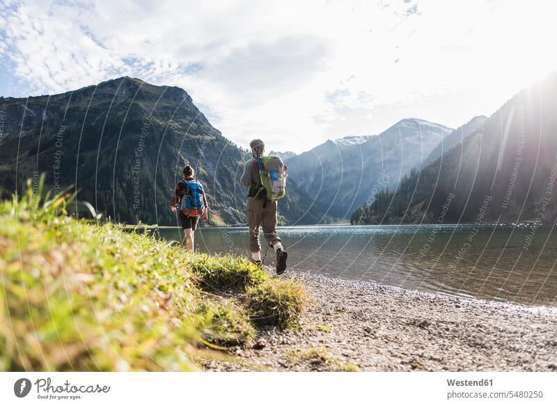 Austria, Tyrol, young couple hiking at mountain lake hike mountain lakes mountains twosomes partnership couples water waters body of water mountainscape