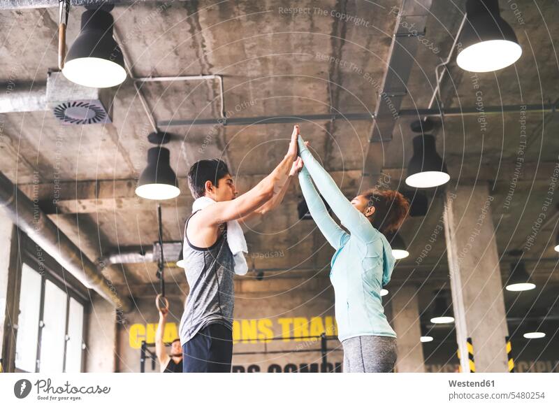 Two young athletes high fiving in gym exercising exercise training practising fitness Fitness training sport sports gyms Health Club Recreational Pursuit