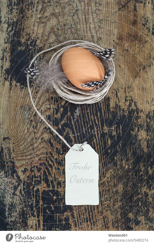 Brown egg in nest built of cord on wood brown eggs Happy Easter wooden Easter egg Easter eggs tag tags simplicity Modest simple close-up close up closeups