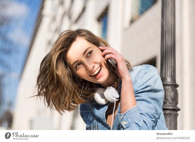 Portrait of laughing woman with headphones on the phone females women call telephoning On The Telephone calling portrait portraits Adults grown-ups grownups
