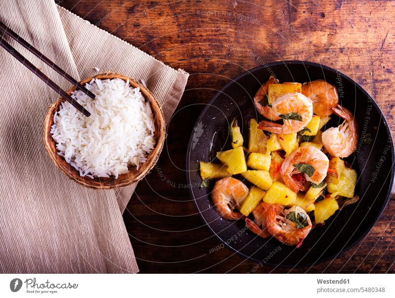 Frying pan of prawns with pineapple, bowl of rice and chopsticks food and drink Nutrition Alimentation Food and Drinks ready to eat ready-to-eat Bowl Bowls