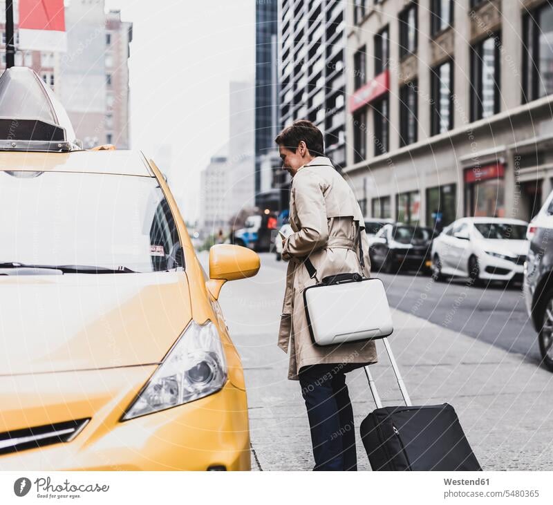 USA, New York City, woman in Manhattan at taxi New York State females women Taxies suitcase suitcases United States United States of America Adults grown-ups