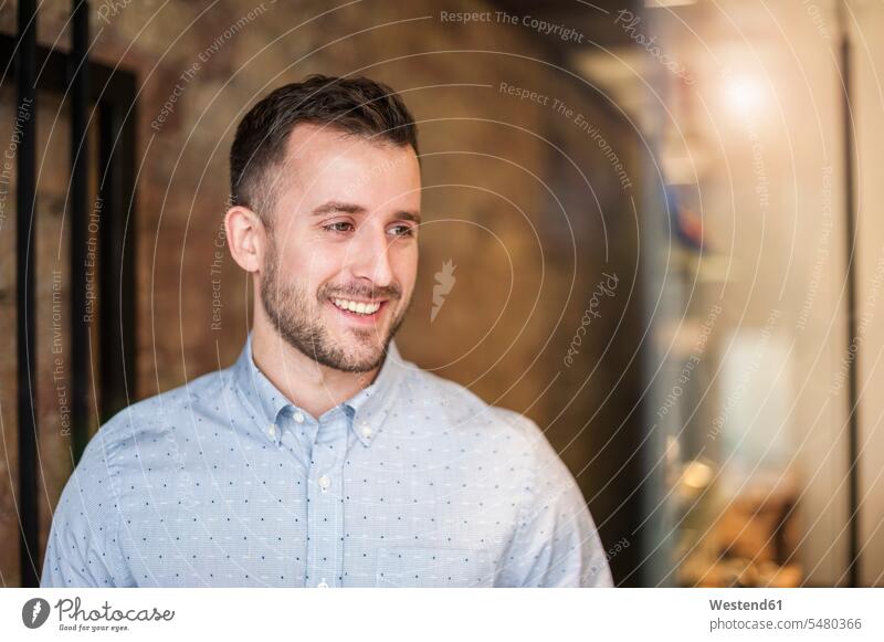 Smiling young man in a shop smiling smile men males Adults grown-ups grownups adult people persons human being humans human beings retail trade trading beard