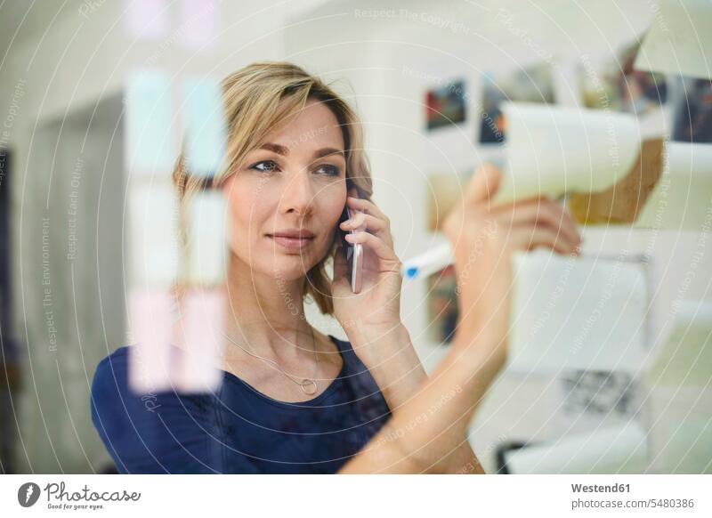 Portrait of blond woman writing on notepad and calling businesswoman businesswomen business woman business women Smartphone iPhone Smartphones portrait
