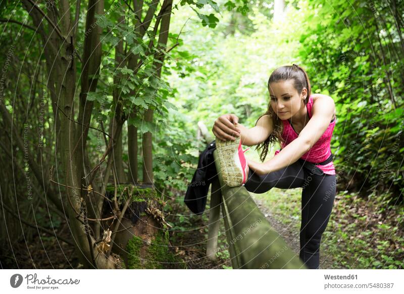 Sportive young woman stretching in forest athlete sportswoman athletes female athlete sportswomen female athletes females Sportspeople Sportsman Sportsperson