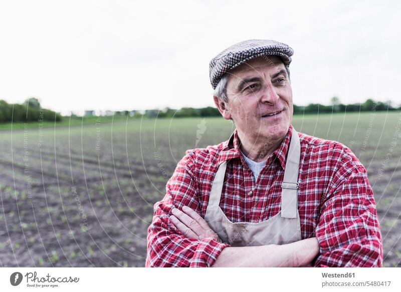 Portrait of farmer in front of a field agriculturists farmers smiling smile agriculture man men males Adults grown-ups grownups adult people persons human being